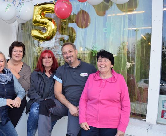 Das Team von Freiwilligen und hauptamtlichen MitarbeiterInnen vor der Second Hand Boutique SOMA Tulln