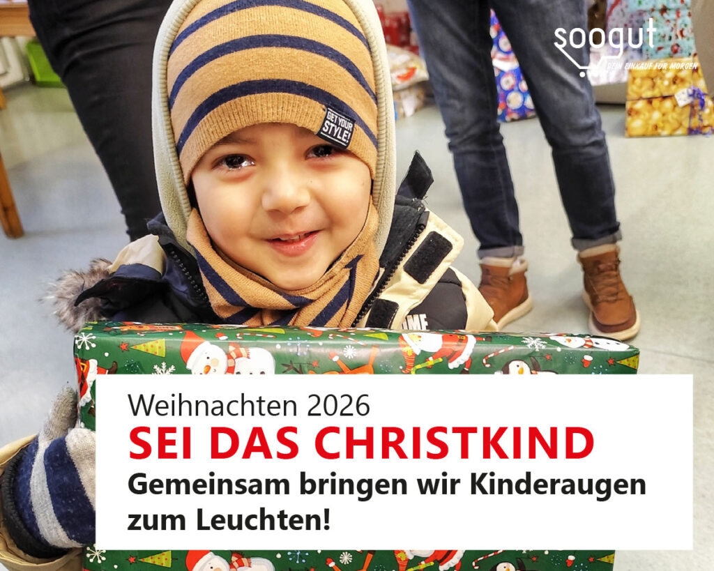 Ein lachendes Kind, mit freudestrahlenden Augen, hält ein Weihnachtsgeschenk in Händen.